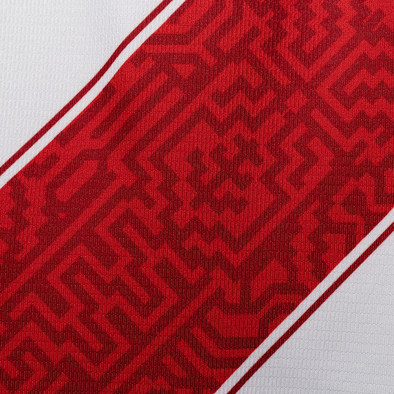 Red patterned diagonal panel on white soccer jersey with contrast border
