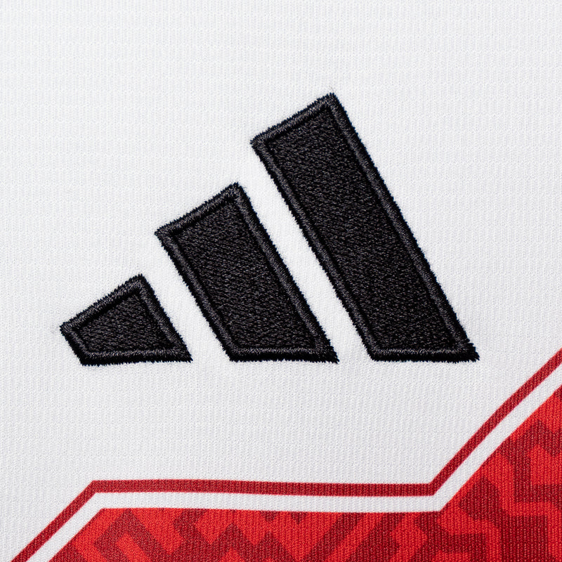 Black adidas three-stripe logo on white soccer jersey with red trim