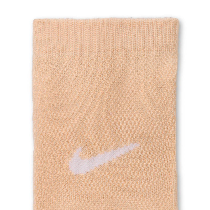 No-show sock fabric close-up in light peach with white swoosh logo