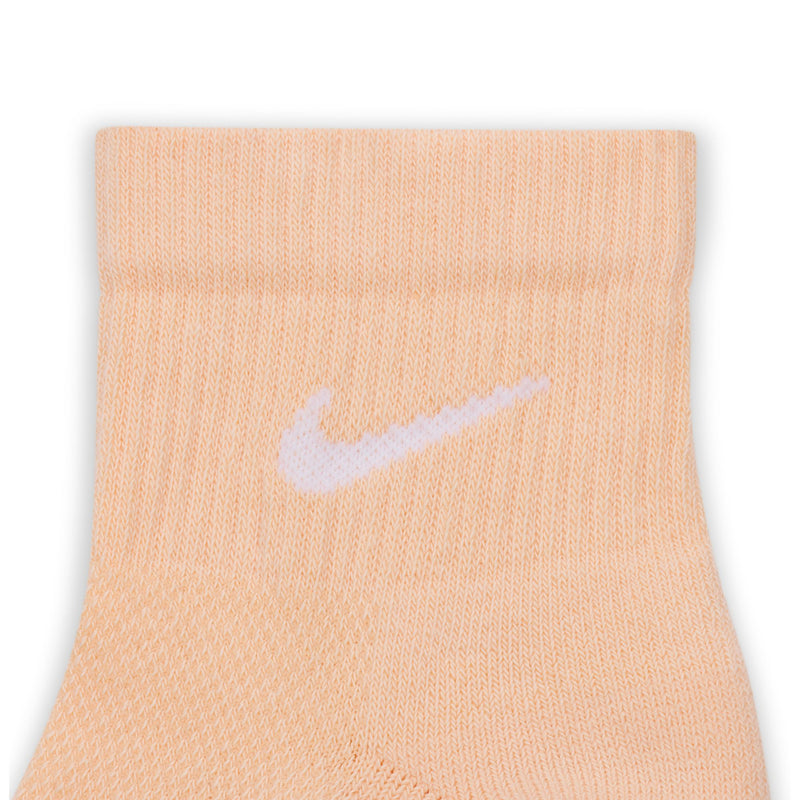 Peach quarter sock close-up with white Nike swoosh on knit cuff