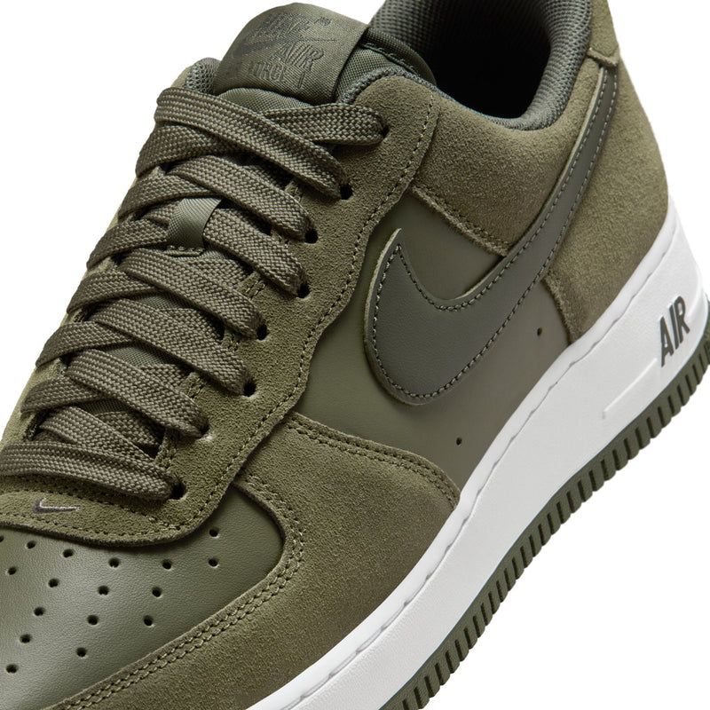 Olive suede sneaker quarter close-up with green laces, Nike swoosh, white 'AIR' panel.