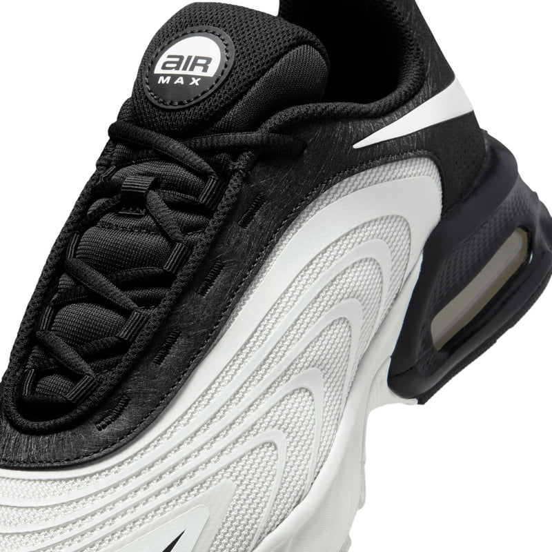 Close-up of men's shoes upper: black mesh, white Swoosh, black laces, Air Max badge