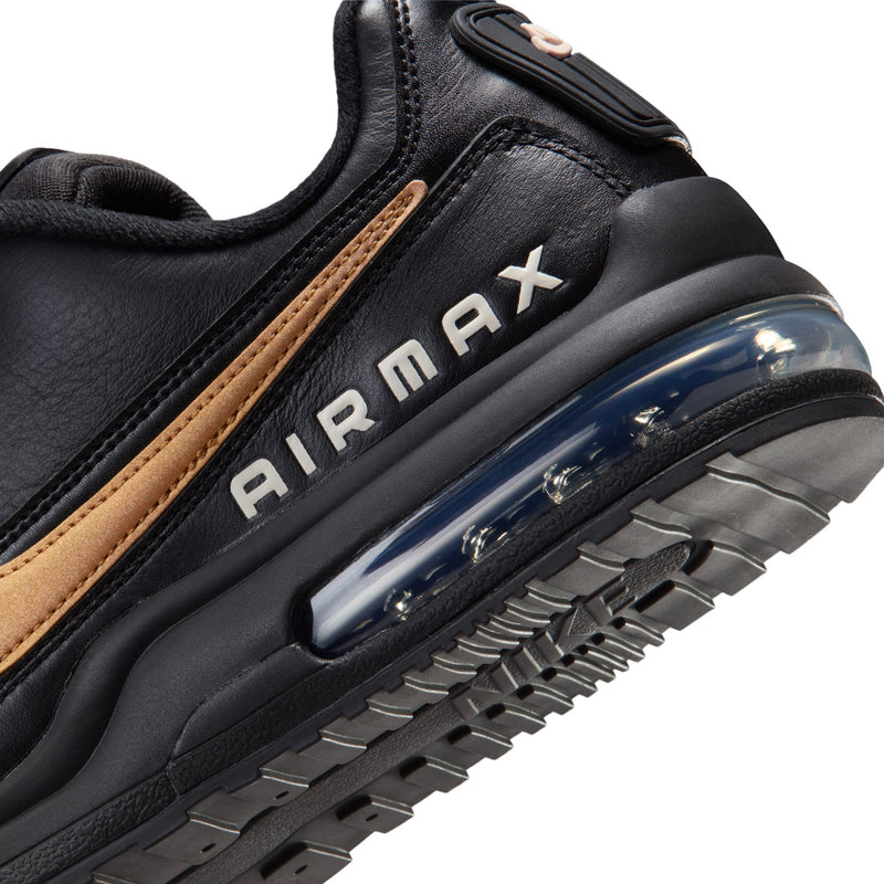 Close-up of men's black sneaker side with AIR MAX lettering and clear air unit window
