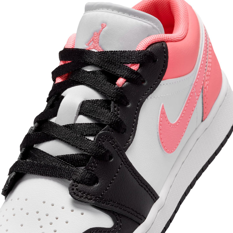 Close-up of youth sneaker laces with black eyelets, pink trim, and white toe panel
