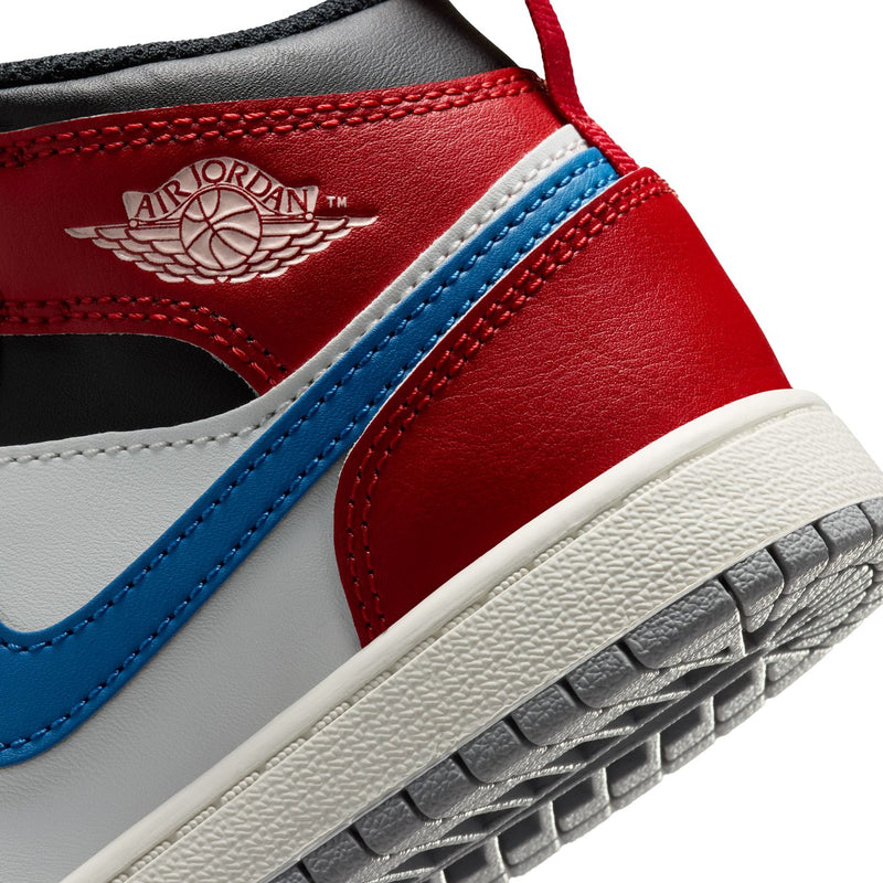 Kids AJ 1 mid-top sneaker close-up on red ankle with AIR JORDAN wings logo