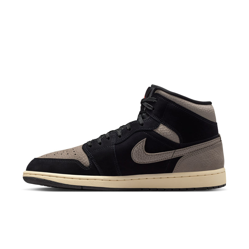 Side view of black and olive grey mid-top sneakers with Nike swoosh and beige sole.