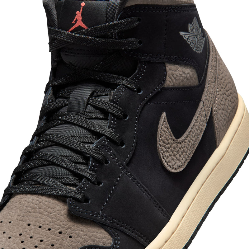 Close-up of black and olive grey mid-top sneaker upper with Nike swoosh and wing logo.