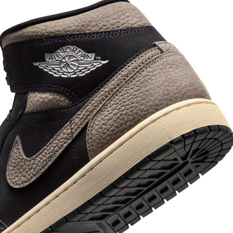 Close-up of black and olive grey mid-top sneaker heel with Wings logo and beige sole.