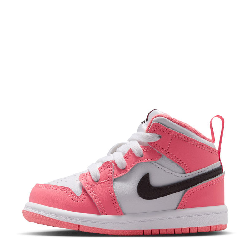 Pink and white toddler mid-top sneakers with white laces, black swoosh, and pink tongue pull