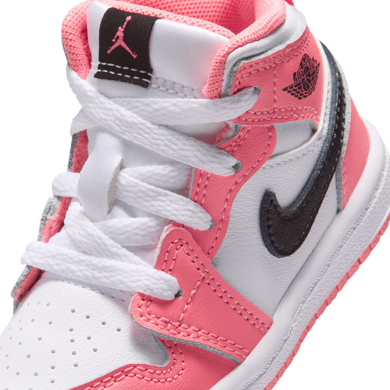 Close-up of pink and white toddler mid-top sneaker with Jordan tongue tag and black swoosh
