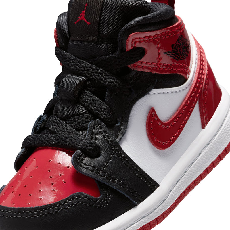 Toddler high-ankle sneakers close-up, black laces with white-and-red Swoosh and red trim