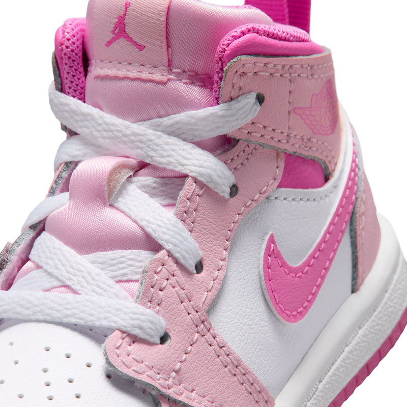 Close-up of pink and white toddler sneaker upper with laces and swoosh logo