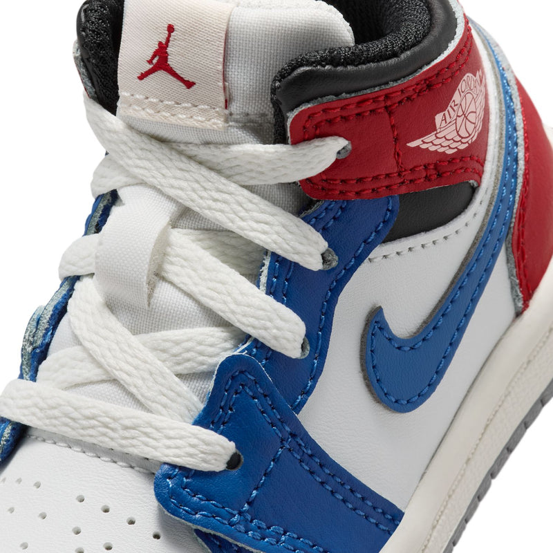 Kids' sneaker close-up: white laces, blue swoosh, red side panel, black trim