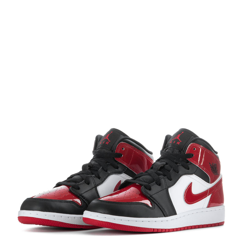 Youth mid-top sneakers pair in black, red, and white with lace-up closure.