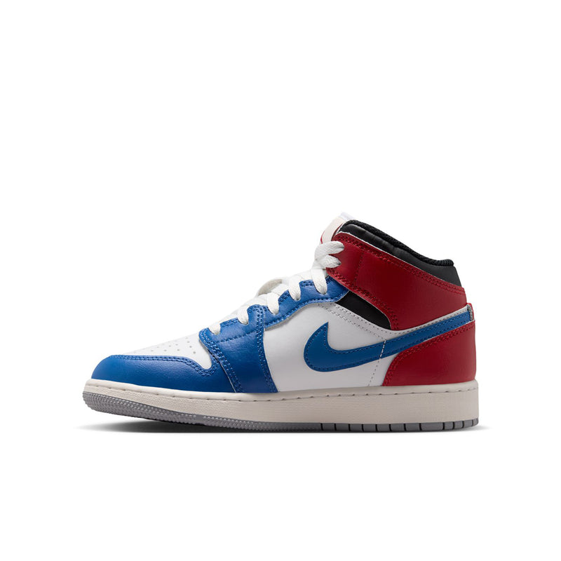 Youth Air Jordan 1 Mid sneakers side angle, white base with blue Swoosh and red overlays.