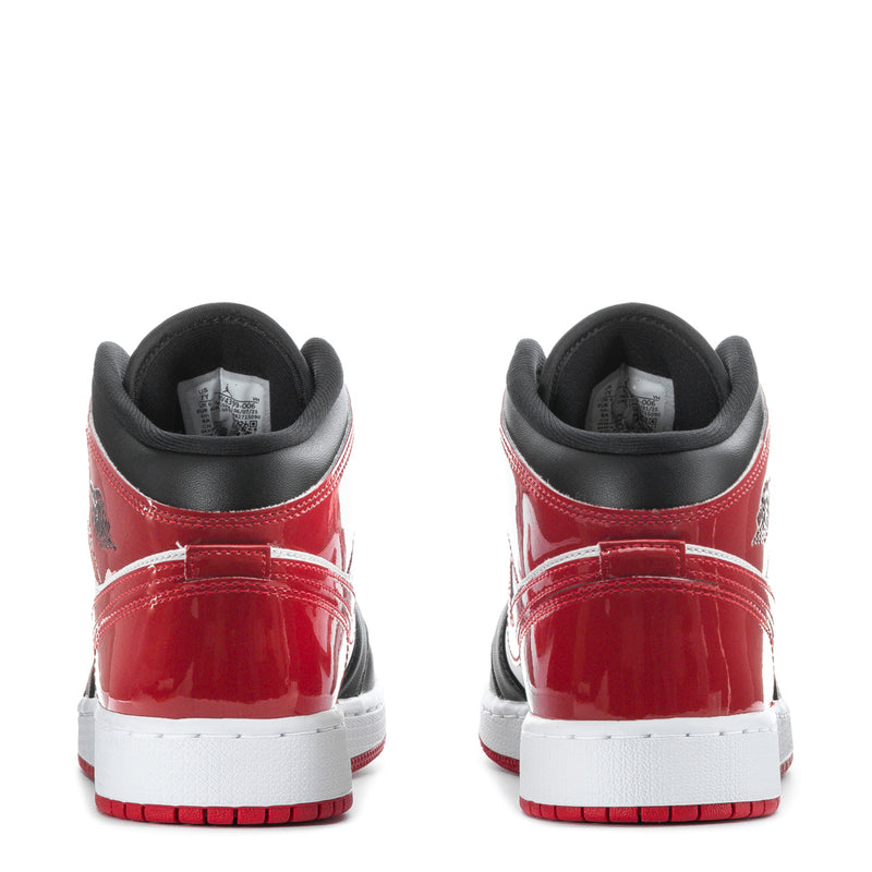 Youth mid-top sneakers back view with red heel and black toe caps.