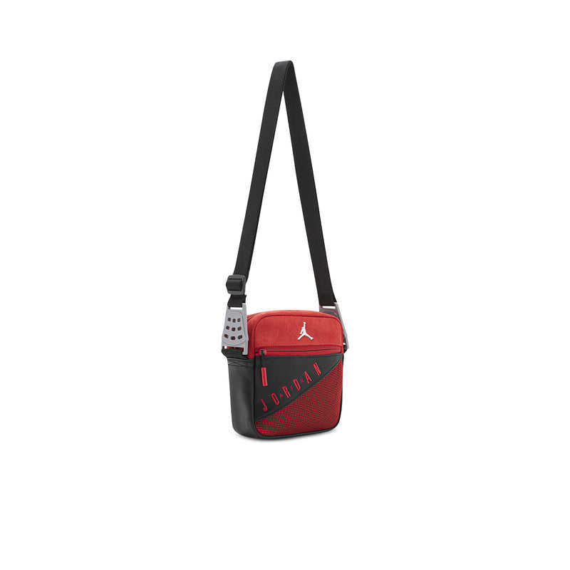 Red crossbody bag with black strap and webbing handle, small size, side view