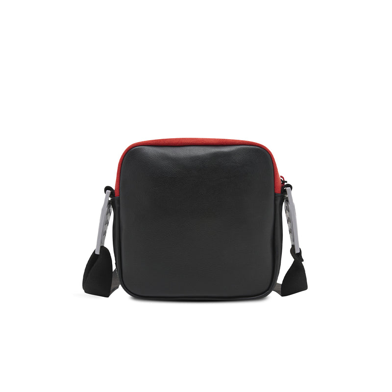 Black crossbody bag with red top trim, dual side handles, and zipper closure