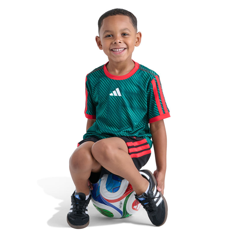 Kids green soccer jersey with red trim and black shorts; adidas logo on chest and legs.