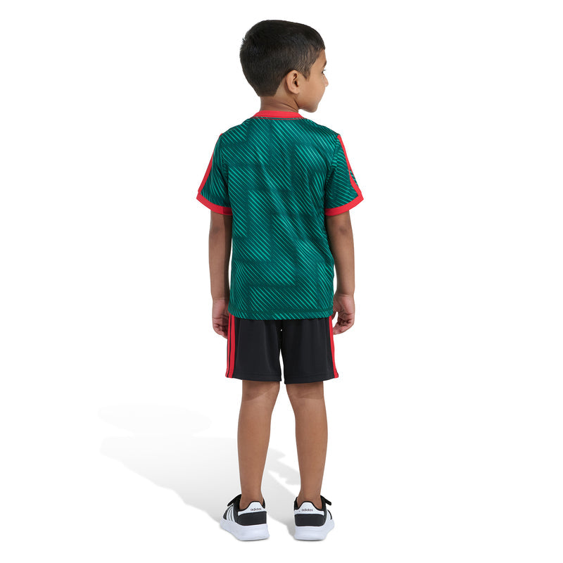 Kids soccer set back view: green jersey with red piping and black shorts with red stripes.