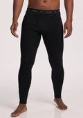A person wearing black Woolx Arctic Leggings with a visible front fly and branded waistband, standing barefoot against a plain light background. | Trell is 6'2", wearing a size M