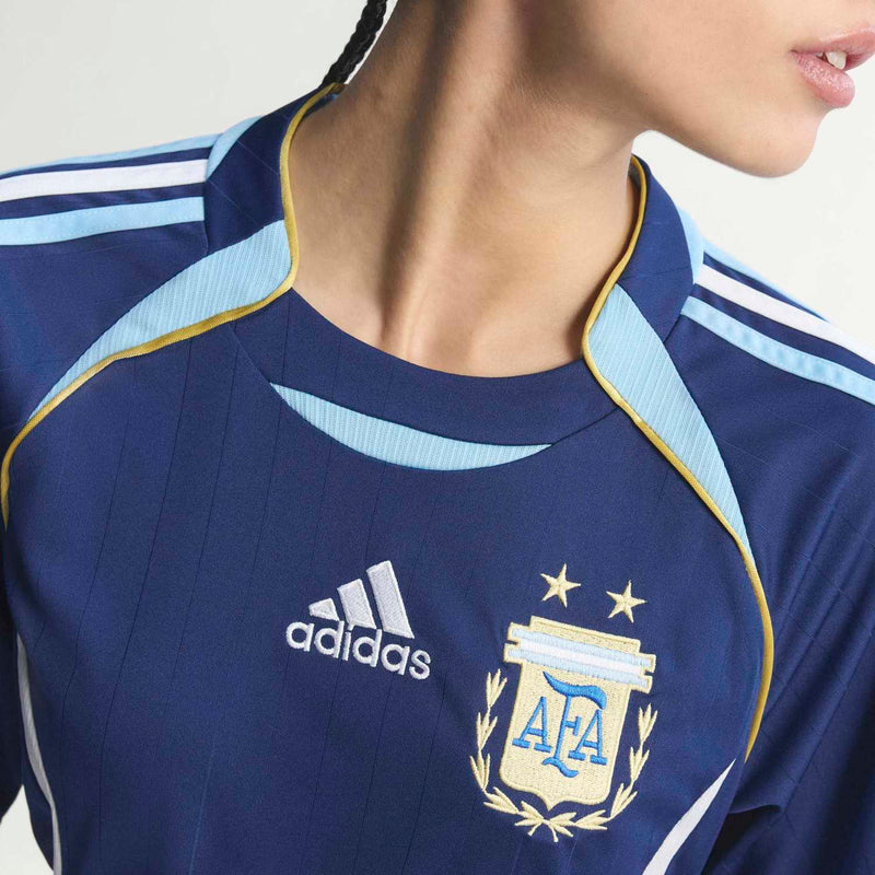 Women's dark blue jersey close-up with adidas logo, AFA crest, and yellow collar trim