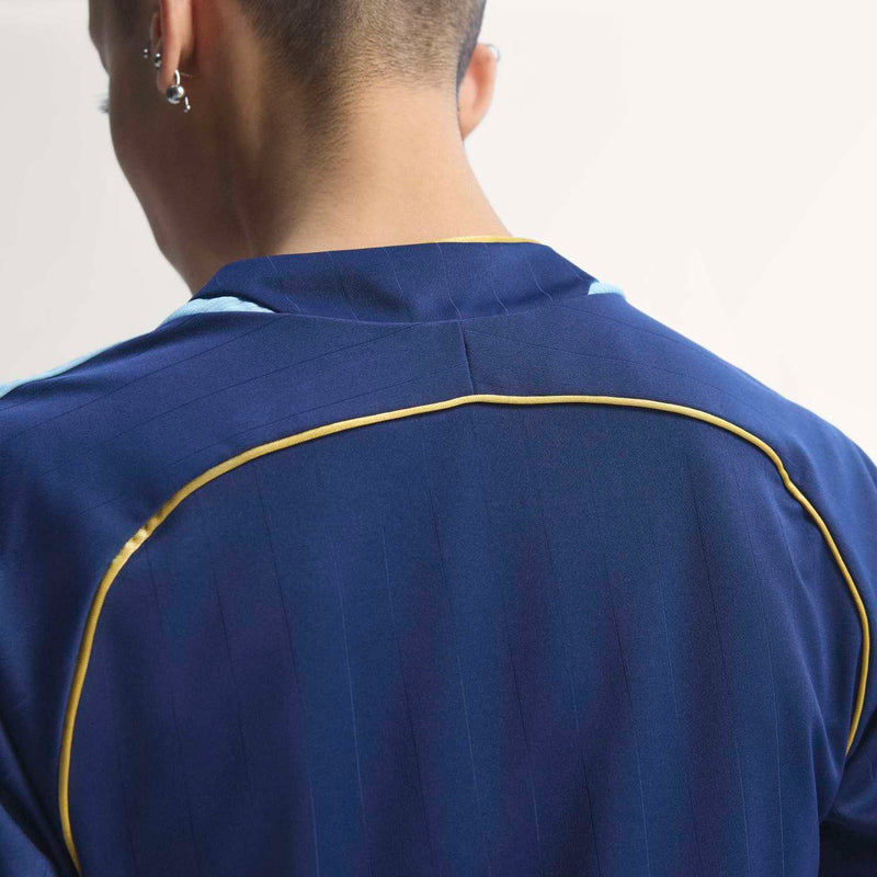 Women's dark blue soccer jersey back with yellow piping along neckline and shoulders