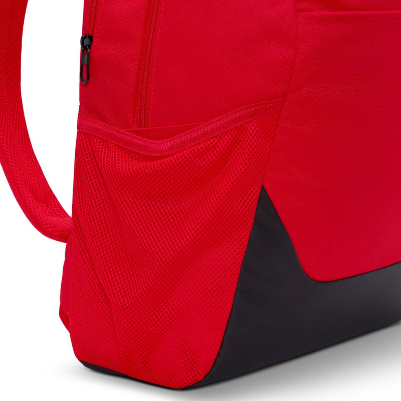 Red backpack side close-up with black lower panel and mesh textured pocket area.