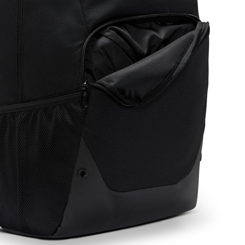 Nike Brasilia backpack side close-up with zip pocket, mesh panel, and black exterior.