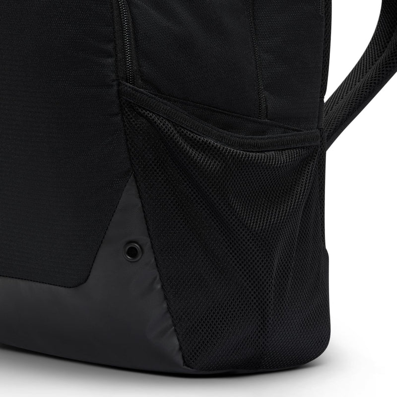 Nike Brasilia backpack lower side view with mesh panel and anchor point grommets.