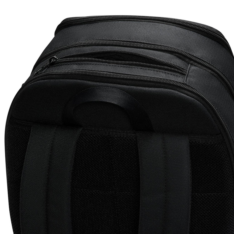 Nike Brasilia backpack top close-up showing multiple zip compartments and carry handle.