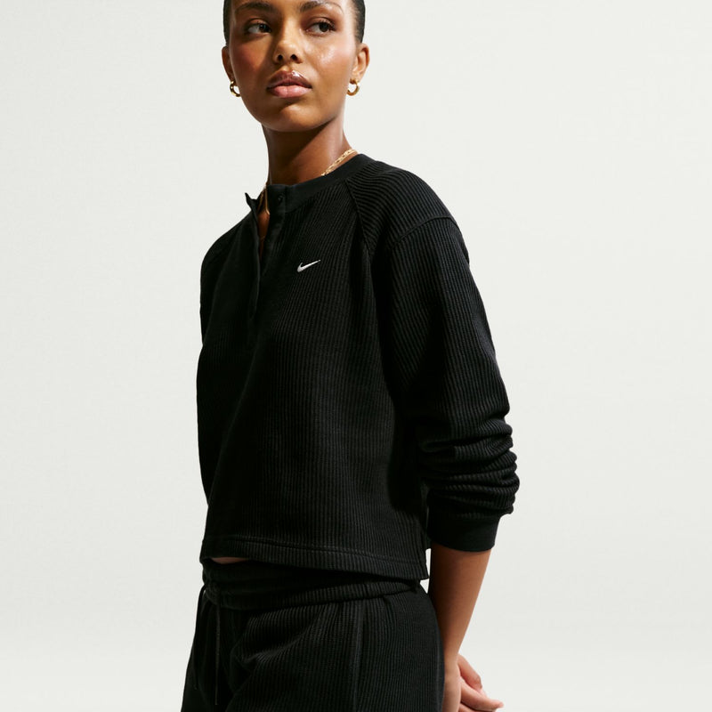 Black waffle-knit womens shorts, side view with elastic waistband and flared hem