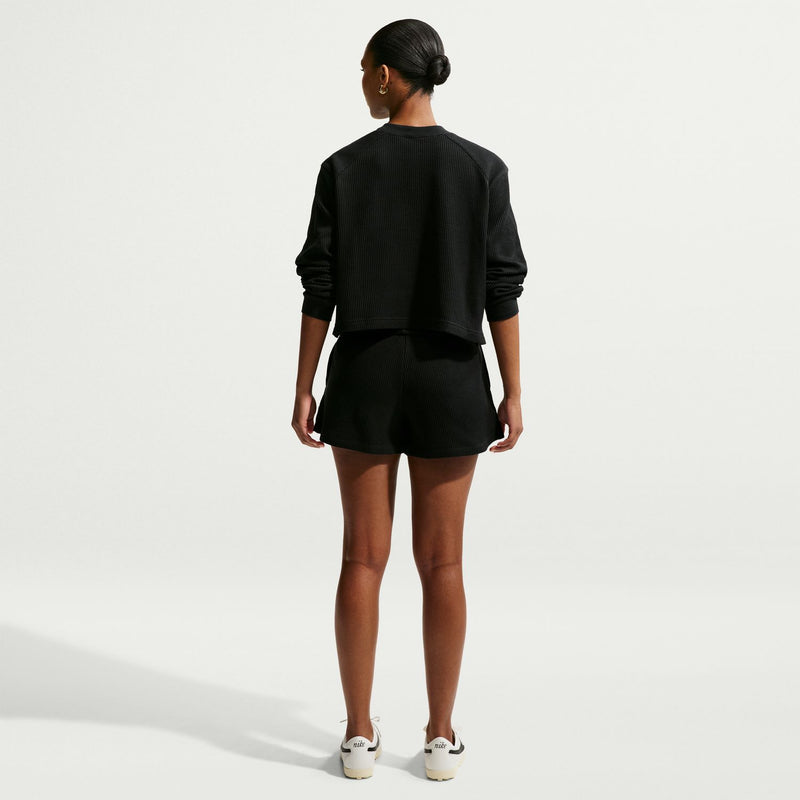 Black waffle-knit womens shorts, back view with elastic waistband and pull-on style