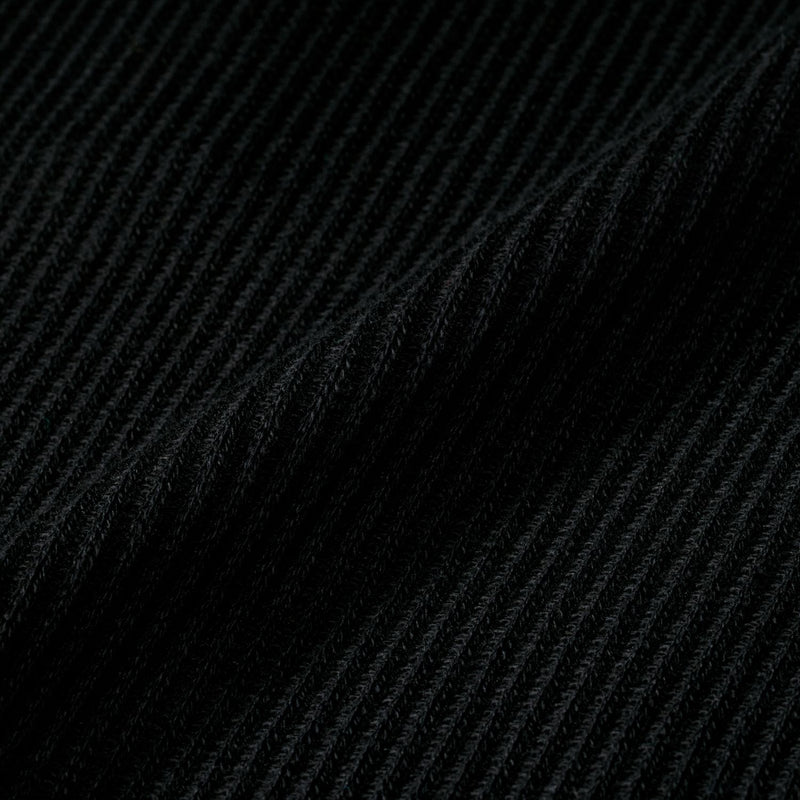 Black waffle-knit fabric texture close-up with fine diamond pattern
