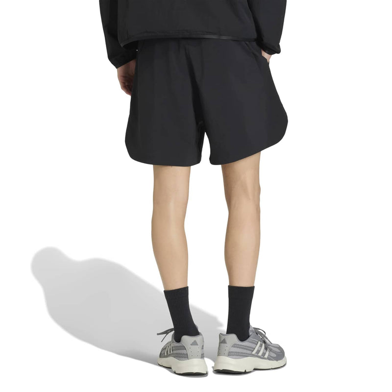 Black men's tech shorts, rear view with elastic waistband and above-knee hem.