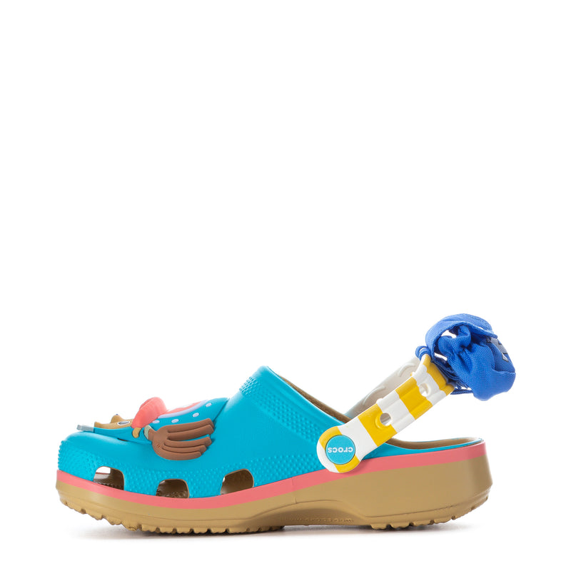 Teal youth clog with pink edge trim, cartoon face Jibbitz, and side decorative charms