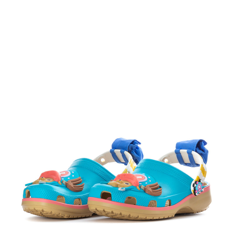Pair of teal youth clogs with pink trim, blue paw charm, and colorful front Jibbitz