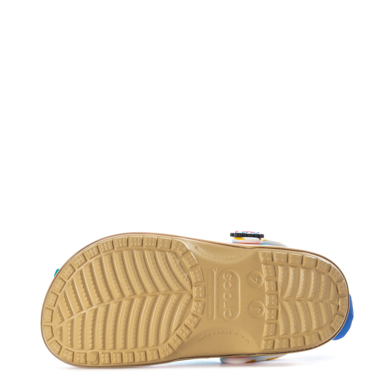 Bottom view of youth teal clogs with textured tan outsole and colorful strap detail