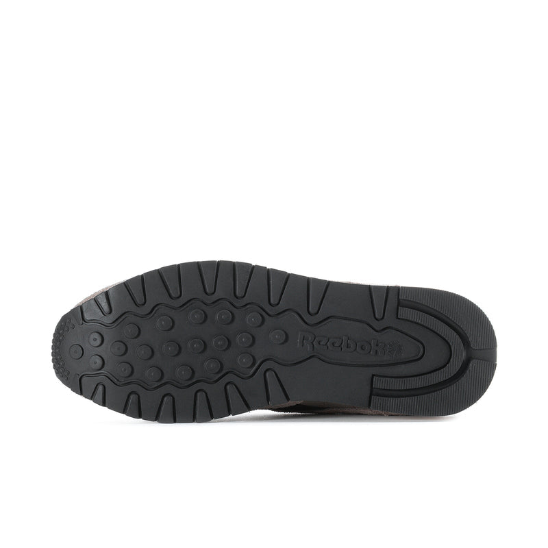 Outsole view of men's Reebok suede sneakers with textured black rubber traction