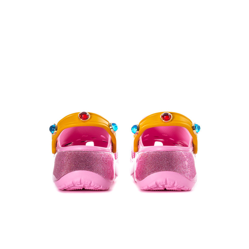 Womens pink platform clogs with yellow heel straps, blue studs, glossy back