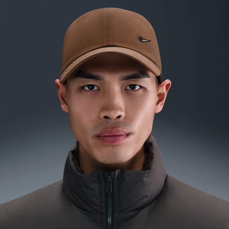 Mosswood brown Nike strapback cap on model with curved brim and black Swoosh