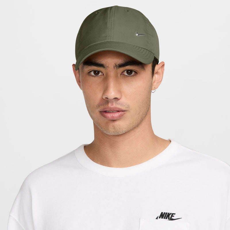 Medium olive Nike strapback cap worn with white crewneck; curved brim, side Swoosh