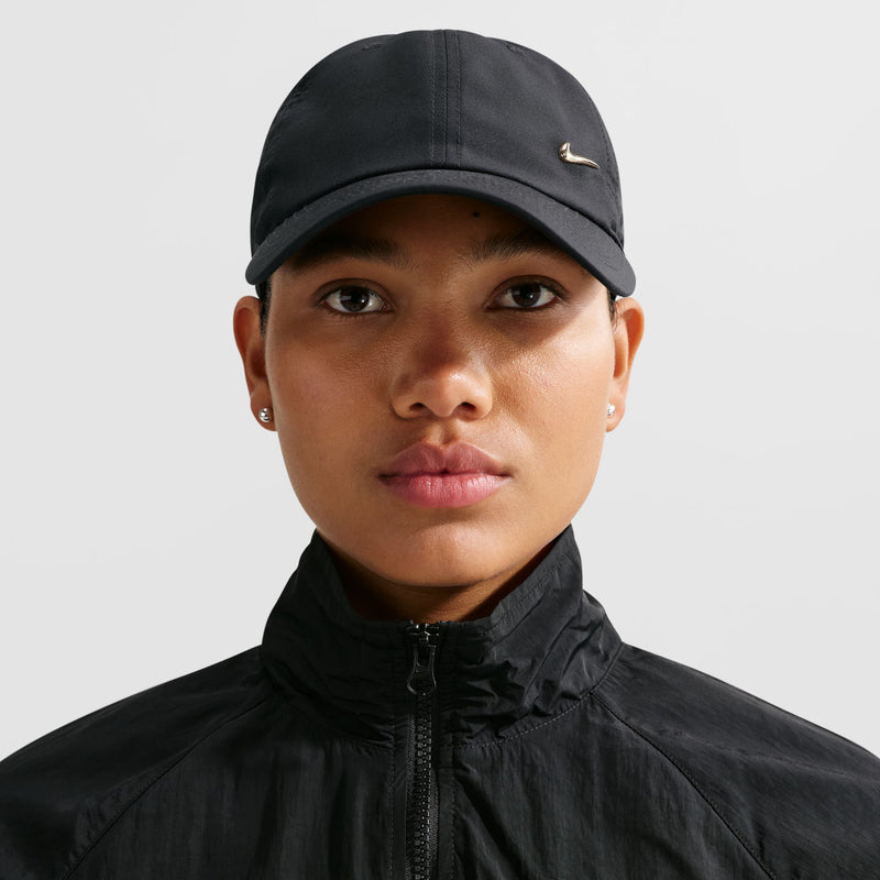 Black strapback cap with metallic gold Nike Swoosh, worn front view, curved brim.