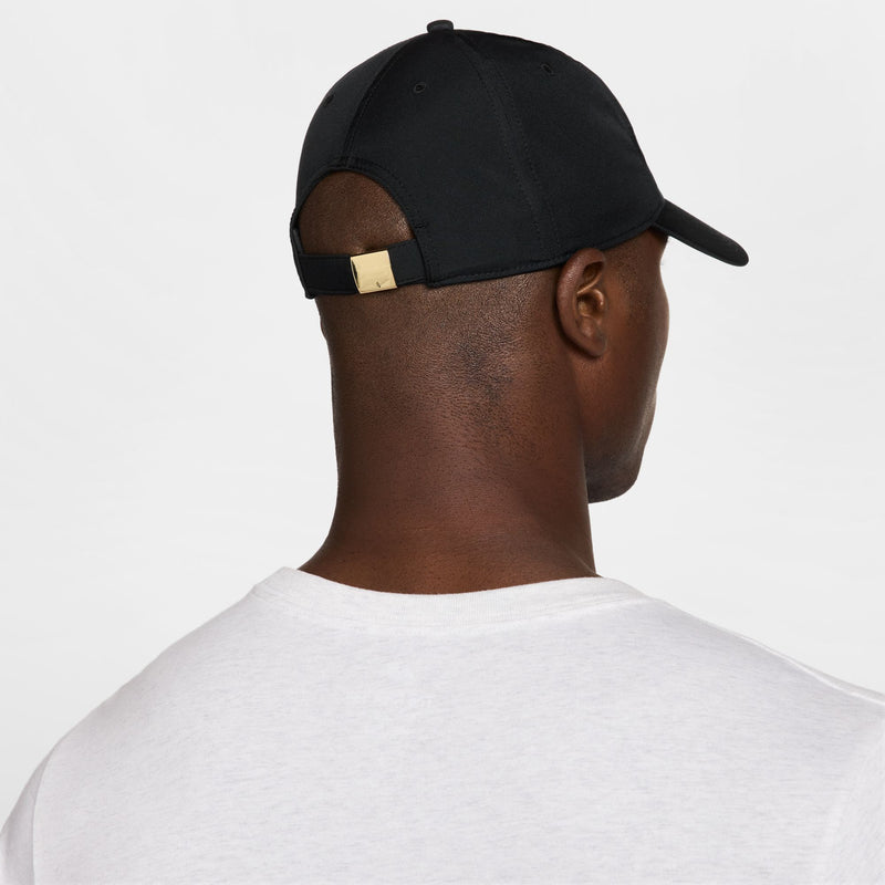 Black strapback cap back view with adjustable strap and metallic gold buckle, curved brim.
