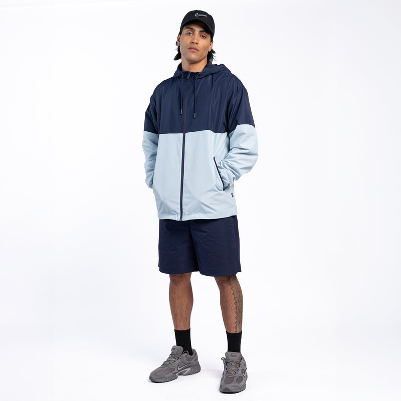 Mens navy and light blue colorblock windbreaker jacket with hood and full-length zipper.