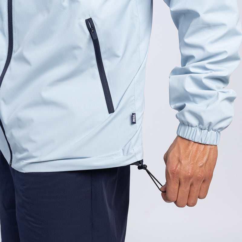 Windbreaker front pocket and zipper with light-blue body, navy trim, elastic cuff.