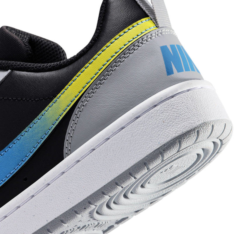 Youth sneaker side close-up with blue swoosh and neon yellow stripe on white