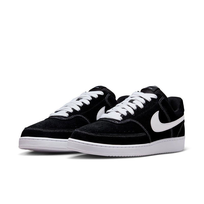 Pair of black low-top sneakers with white Swoosh, white laces, and white sole