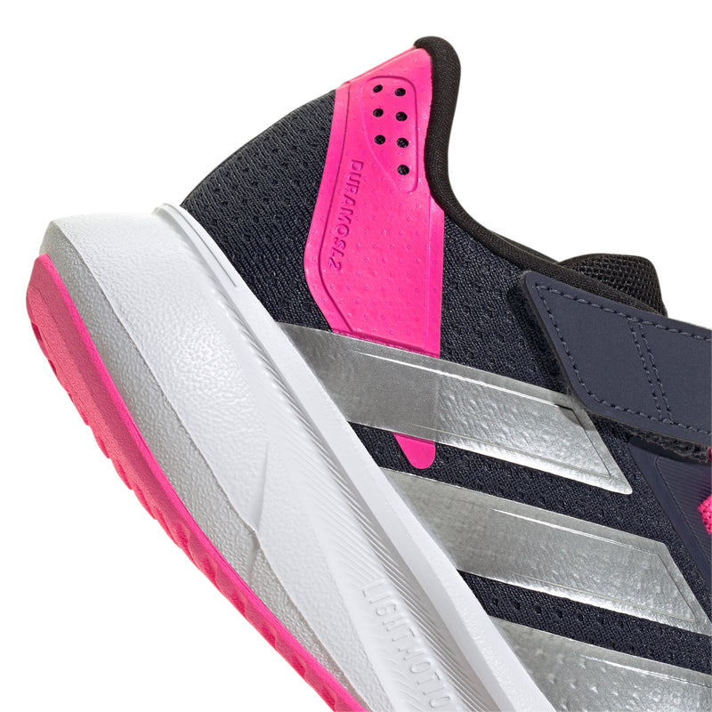 Close-up of navy kids shoe tongue with pink padding, silver stripe detail, white sole