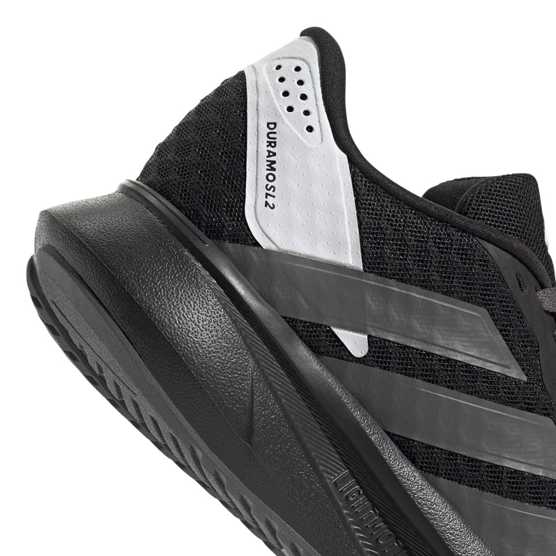 Youth running shoe tongue and side close-up, white label and gray stripe detail